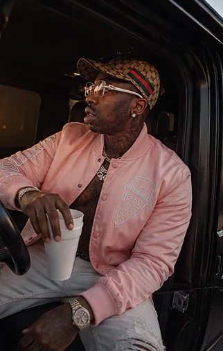 Poochie MrPrince seated in a black truck