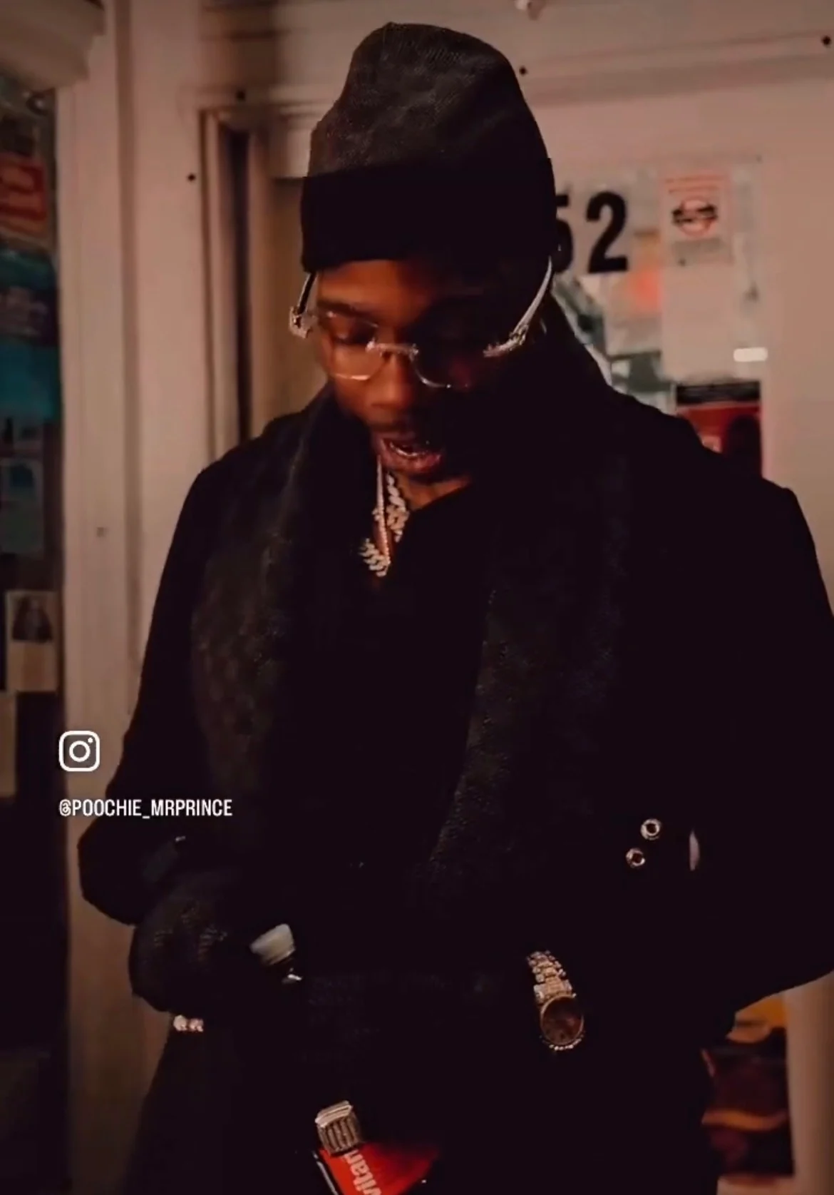 Poochie MrPrince at night in an all-black fur coat and scarf